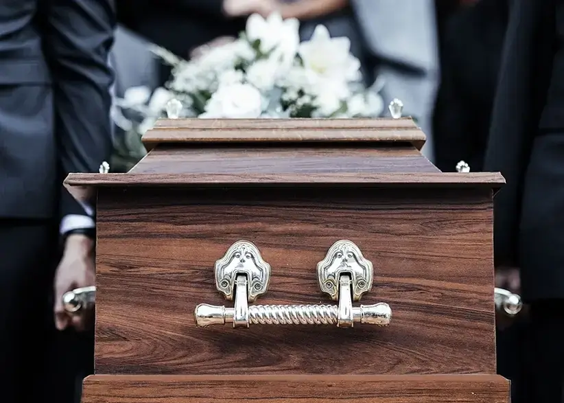 Holzsarg mit Blumenschmuck